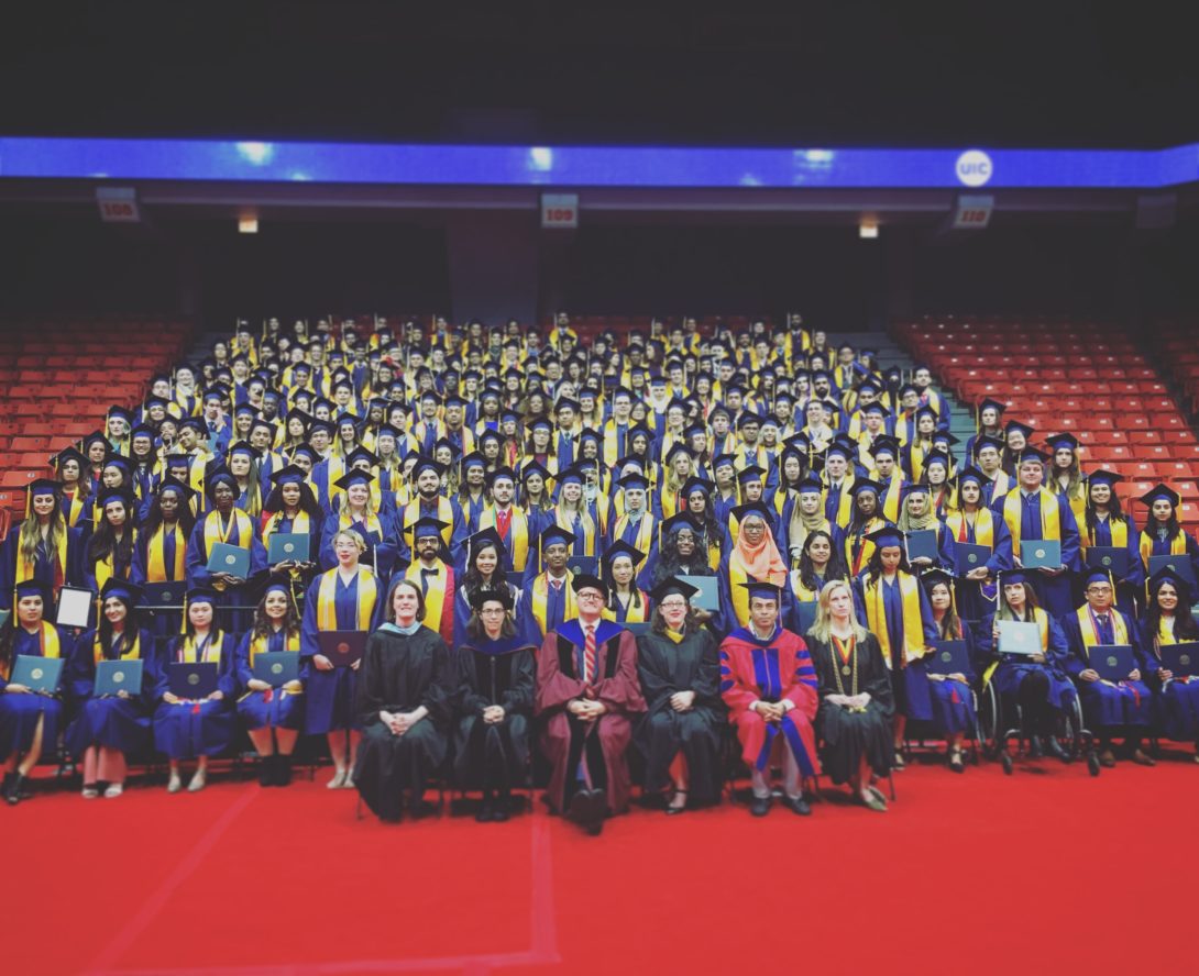 Graduating Class of 2018, in the stands within the UIC Pavilion, with Honors College deans and faculty seated in the front row