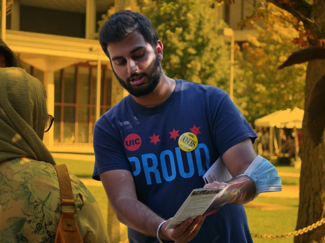 Student standing holding a brochure