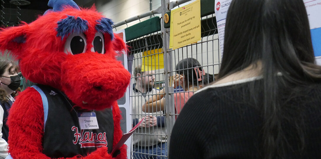 Sparky D. Dragon talking with Student
