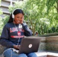 Student looking at computer outside