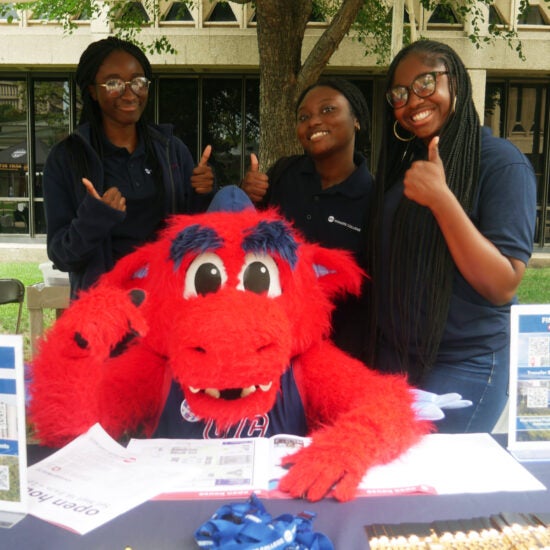 Sparky the dragon with three Honors students