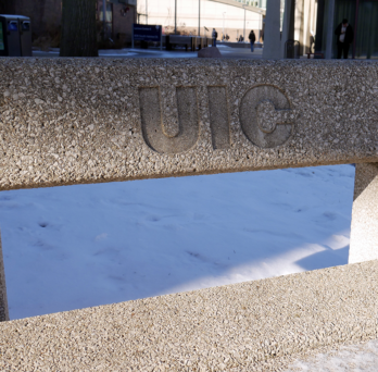 Picture of a bench with UIC logo on UIC campus during winter 